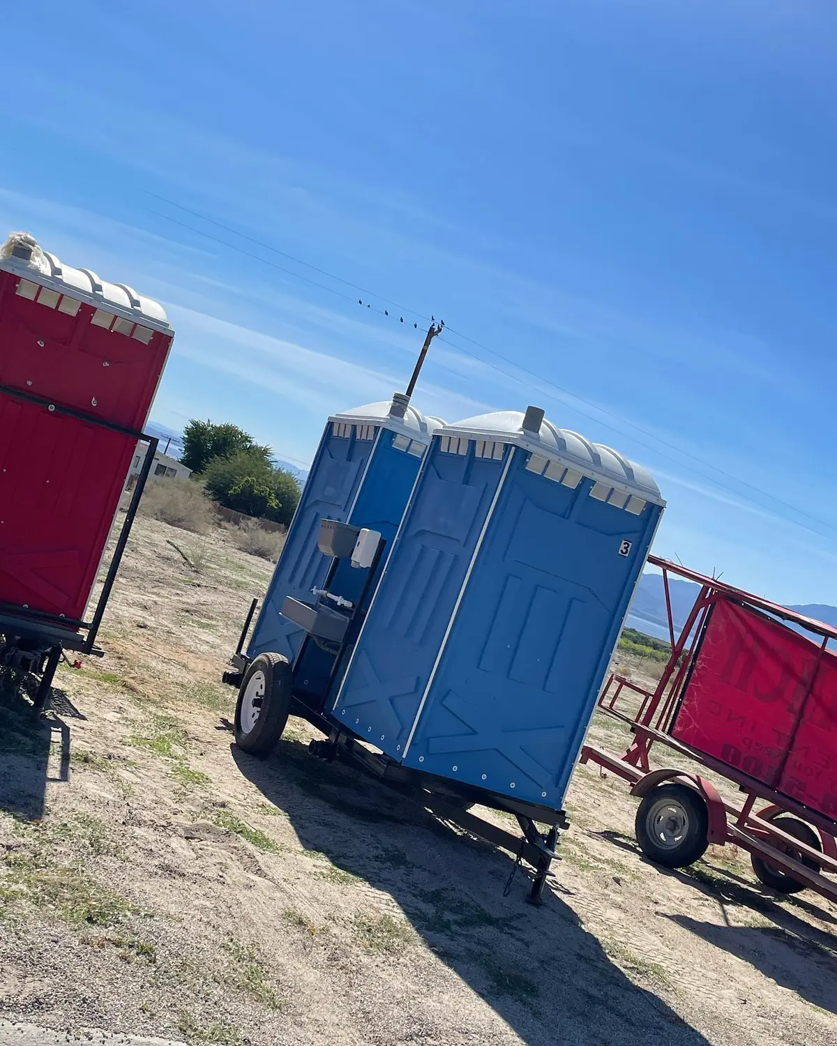 Side view of a towable portable toilet on a single-axle trailer